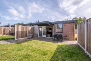 a house with a patio and a fence at Zeester in Serooskerke