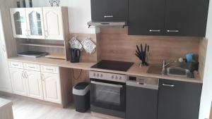 uma cozinha com armários brancos e um forno de fogão preto em Ferienhaus Renate 7 em Thale