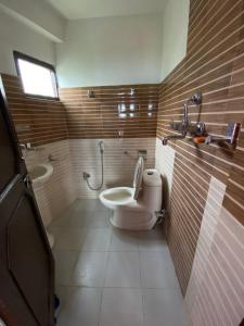 a bathroom with a toilet and a sink at The Nest Guest House in Changunarayan