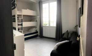 Cette chambre comprend un canapé et des lits superposés. dans l'établissement Chalet basque 6 couchages centre ville Biarritz, à Biarritz