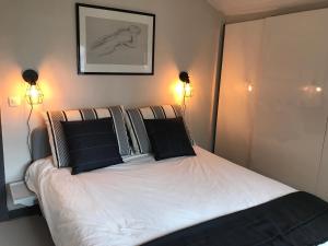 Schlafzimmer mit einem Bett mit schwarzen und weißen Kissen in der Unterkunft Chalet basque 6 couchages centre ville Biarritz in Biarritz