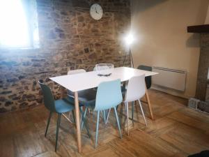 QuettehouにあるMaison Normande proche de la mer et des lieux touristiquesの石壁の部屋(白いテーブルと椅子付)