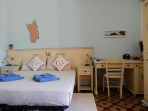 1 dormitorio con 1 cama con 2 toallas azules en B&B Eleonora D'Arborea, Centro Storico en Posada