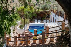 una vista aérea de una piscina con sillas y una valla en Finca Fabulosa - Nudist Resort - Adults Only, en Álora