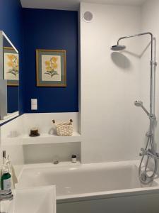 een badkamer met een wit bad en een blauwe muur bij Domek Pod Sosnami in Rozewie