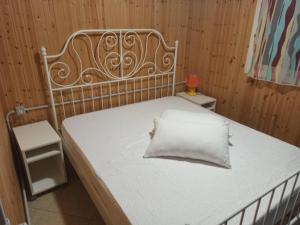 una cama con una almohada blanca encima en Camping Poseidonia, en Paestum
