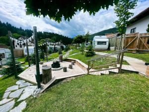 een houten brug in een tuin met een trailer bij Glamping Langus in Topolšica