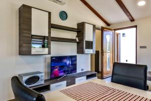 a dining room with a table and a television at Casa Istriana Dajla in Novigrad Istria