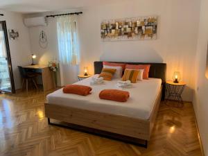 1 dormitorio con 1 cama grande con almohadas de color naranja en Puntižela-Patty, en Pula