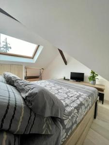 a bedroom with a bed with a desk and a window at Petit studio vue lac / La Talloirdaze in Talloires