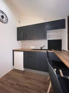 a kitchen with a table and a clock on the wall at Petit studio vue lac / La Talloirdaze in Talloires