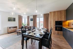 a dining room and living room with a table and chairs at CHILLIapartamenty - Mazowiecka - CASARITAS in Kołobrzeg