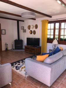 uma sala de estar com um sofá e uma televisão de ecrã plano em Casa La Alegria 37 em Málaga