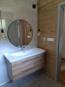 La salle de bains est pourvue d'un lavabo blanc et d'un miroir. dans l'établissement Apartmán Mýto, à Mýto pod Ďumbierom