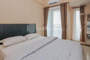 a large white bed in a bedroom with windows at RedLiving Apartemen Sayana - Family Group Tower Cha in Hutanhawit +20 photos