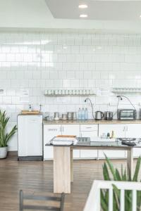 a large kitchen with white appliances and a counter at Connect Hostel in Chiang Rai