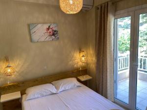 sypialnia z łóżkiem z 2 lampami i oknem w obiekcie Blue Lagoon w mieście Lutraki