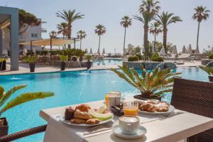 stolik ze śniadaniem przy basenie w obiekcie Marins Suites - Adults Only Hotel w Cala Millor