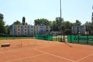 a tennis court with a net and a building at Hotel KOREKT in Banka