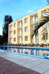 Banka的住宿－Hotel KOREKT，一座带椅子的建筑,前面有一个游泳池