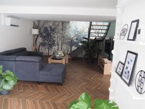 ein Wohnzimmer mit einem blauen Sofa und einer Treppe in der Unterkunft Gîte Le Renouveau avec jacuzzi privatif in Laveline