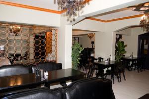 a dining room with tables and chairs and a chandelier at Hotel Gloria Budapest City Center in Budapest