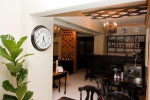 a clock on the wall of a restaurant with a table at Hotel Gloria Budapest City Center in Budapest