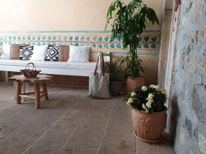 a bench in a room with potted plants and a table at Aretousa Deluxe Downtown Apartment in Skala