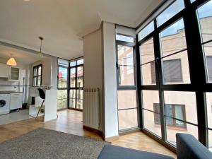 uma sala de estar com janelas grandes e uma cozinha em Apartamento Melisa VUT700 em León