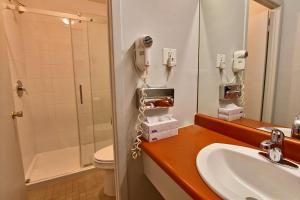 a bathroom with a sink and a blow dryer at Hotel-Motel La Difference in Sainte-Marie +26 photos