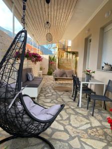 a patio with a swinging chair in a room at ILIOS apartment in Nydri