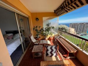 a balcony with a bedroom and a bed and a balcony with a view at Une terrasse sur Monaco logement 2 chambre in Beausoleil