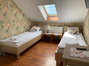a small room with two beds and a window at Babie Lato in Leśna