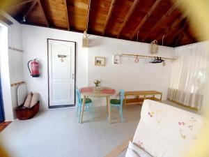 TabayescoにあるEco Casa Alma,Montaña, Campo y Playaのテーブルと椅子、ドアが備わる部屋