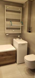 bagno bianco con servizi igienici e lavandino di Apartament Prymus z garażem a Kołobrzeg