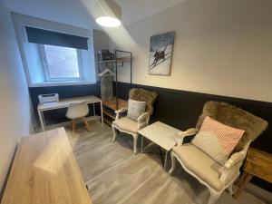 a waiting room with chairs and a table and a desk at Alpine Apartments - 2 in Blairgowrie