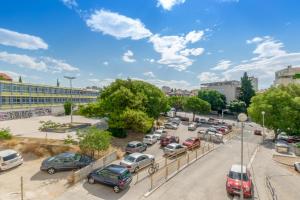 Beaucoup de voitures garées sur un parking dans l'établissement Apartment Omiška, à Split