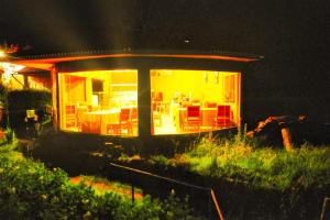 a small house with a lit up room with chairs at Allpa Tika Lodge in Amantani