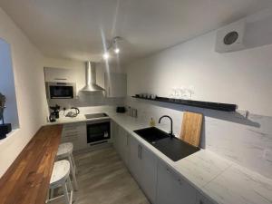 a white kitchen with a sink and a counter at Alpine Apartments - 2 in Blairgowrie