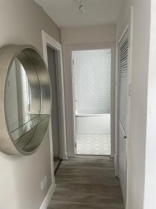 corridoio con specchio circolare sul muro di Alpine Apartments - 2 a Blairgowrie