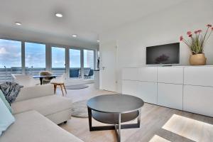 a living room with a couch and a table at Strandperle Ostsee Suite 1 in Niendorf