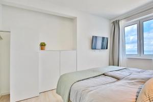 Habitación blanca con cama y ventana en Strandperle Ostsee Suite 1 en Niendorf