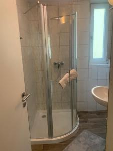 una ducha con una puerta de cristal junto a un lavabo en Smart Stay Apartment, en Feldkirch