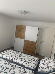 Schlafzimmer mit einem Bett und einem Kopfteil aus Holz in der Unterkunft Smart Stay Apartment in Feldkirch