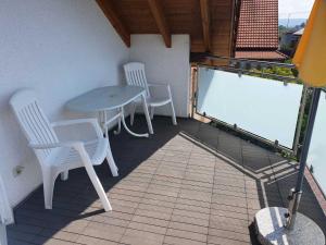 a balcony with a table and chairs on a balcony at M&J FeWo in Kappel-Grafenhausen