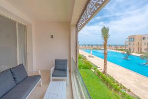 einen Balkon mit Poolblick in der Unterkunft Mangroovy 2 Bedroom Sea View Apartment, Pool & Beach in Hurghada