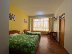 Habitación de hotel con 2 camas y mesa en Monteverde Tarapoto "Eco-Friendly", en Tarapoto