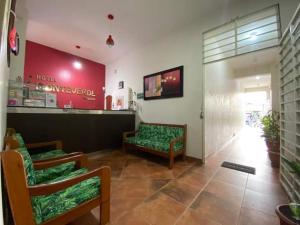 um lobby de loja com duas cadeiras verdes e uma sala de espera em Monteverde Tarapoto "Eco-Friendly" em Tarapoto