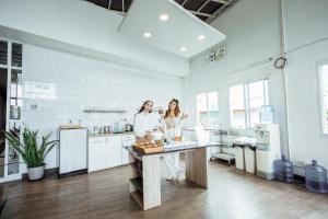 two women standing at a counter in a kitchen at Connect Hotel Chiang Rai in Chiang Rai