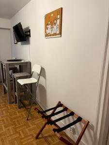 a room with a white wall with a chair and a desk at Hauteurs de Trouville - Studio avec terrasse au calme in Trouville-sur-Mer